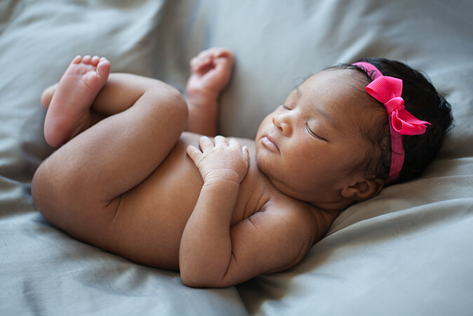 newborn baby girl sleeping pink headband 